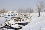 3954454-snow-covered-old-boats-in-frozen-marina.webp