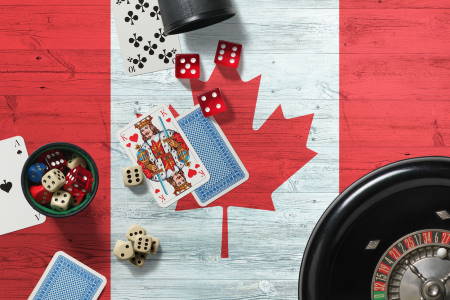 Canada casino theme. Aces in poker game, cards and chips on red table with national wooden flag background. Gambling and betting.