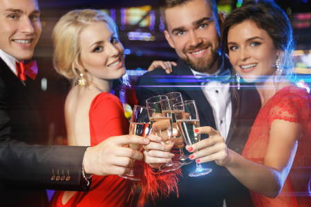 Group of happy people during celebration is drinking sparkling wine in the casino