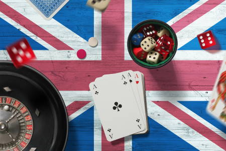 United Kingdom casino theme. Aces in poker game, cards and chips on red table with national flag background. Gambling and betting.